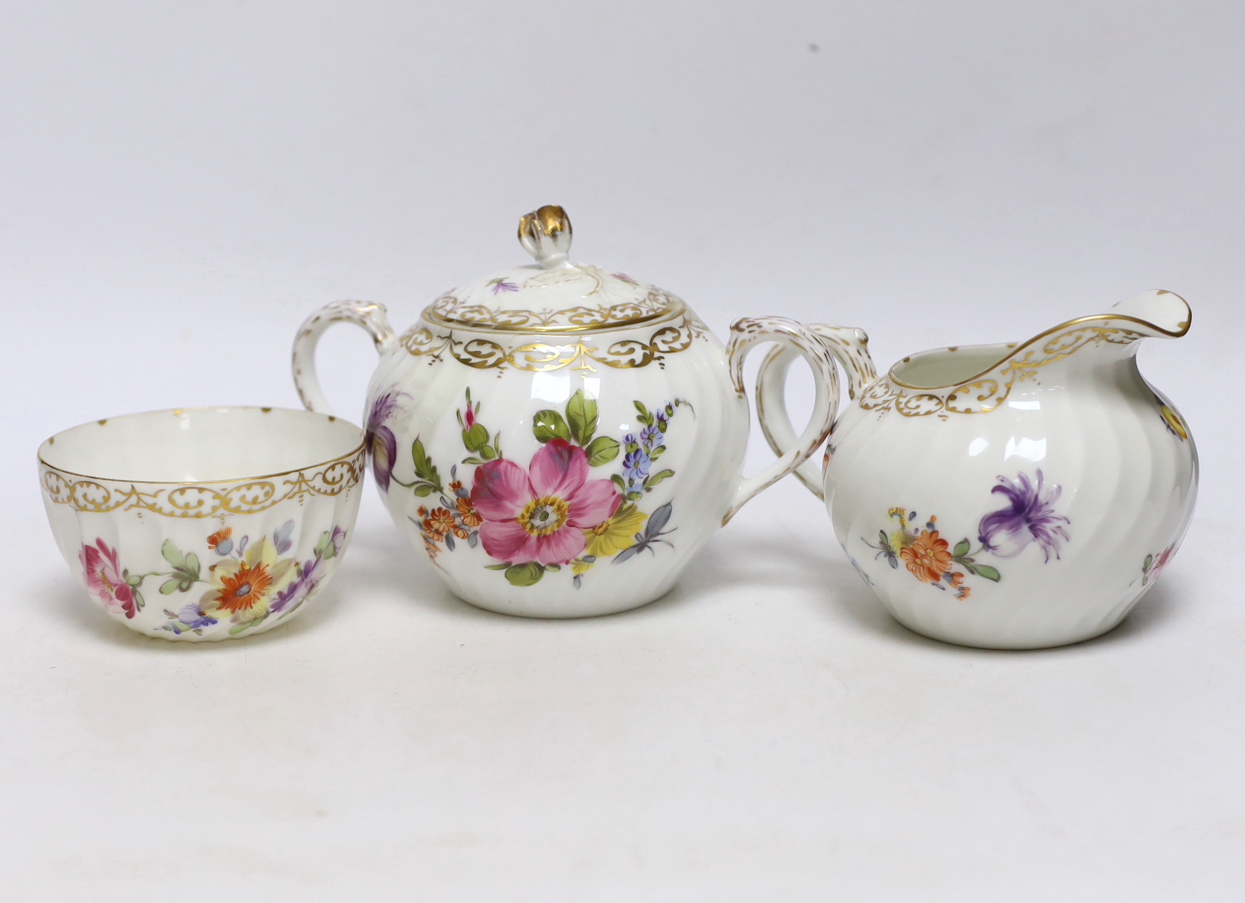A Nymphenburg floral decorated teapot, milk jug and sugar bowl, teapot 13c high
